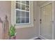 Beige front door with a glass storm door and security system at 3275 Osprey Ln, Port Charlotte, FL 33953