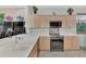 Modern kitchen with stainless steel appliances and light wood cabinets at 3275 Osprey Ln, Port Charlotte, FL 33953
