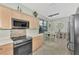 Eat-in kitchen with stainless steel appliances and light wood cabinets at 3275 Osprey Ln, Port Charlotte, FL 33953