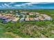 Aerial view of upscale community with lake, lush landscaping, and numerous homes with pools at 3275 Osprey Ln, Port Charlotte, FL 33953