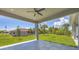 Covered patio with ceiling fan, overlooking a grassy backyard at 8111 Arlewood Cir, Port Charlotte, FL 33981