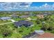 Aerial view of a house and neighborhood, showcasing a canal and lush landscaping at 8111 Arlewood Cir, Port Charlotte, FL 33981