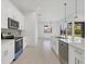 Open concept kitchen with white cabinets, stainless steel appliances and a large island at 8111 Arlewood Cir, Port Charlotte, FL 33981