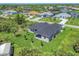 Aerial view of a house and neighborhood, showcasing a canal and lush landscaping at 8111 Arlewood Cir, Port Charlotte, FL 33981