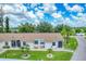 Exterior view of a light-colored building with brown roof, landscaping, and palm trees at 6796 Gasparilla Pines Blvd # 48, Englewood, FL 34224