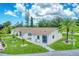Exterior view of a light-colored building with a brown roof and lush lawn at 6796 Gasparilla Pines Blvd # 48, Englewood, FL 34224