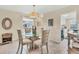 Dining room with glass table and four chairs, view to kitchen at 6796 Gasparilla Pines Blvd # 48, Englewood, FL 34224