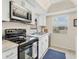 Modern kitchen with stainless steel appliances and white cabinets at 6796 Gasparilla Pines Blvd # 48, Englewood, FL 34224