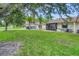 Landscaped backyard with mature trees at 6796 Gasparilla Pines Blvd # 48, Englewood, FL 34224
