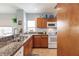 Kitchen with granite countertops, wooden cabinets, and white appliances at 8409 Placida Rd # 308, Placida, FL 33946