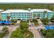 Aerial view of a teal building with parking and lush landscaping at 8409 Placida Rd # 308, Placida, FL 33946