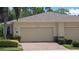 Tan house exterior with double garage and nicely landscaped front yard at 13524 Abercrombie Dr, Englewood, FL 34223