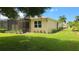 Well-maintained house with a screened patio, lush lawn, and attractive landscaping at 13524 Abercrombie Dr, Englewood, FL 34223