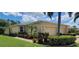 Tan house exterior with double garage, landscaping, and a walkway at 13524 Abercrombie Dr, Englewood, FL 34223