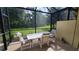 Screened patio with table and chairs, overlooking a backyard at 13524 Abercrombie Dr, Englewood, FL 34223