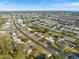 Expansive aerial view of a quiet residential neighborhood with well-maintained streets and lush landscaping under a clear blue sky at 6517 Kenwood Dr, North Port, FL 34287