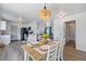 Open concept dining area with wood table, white chairs, kitchen and living room views at 6517 Kenwood Dr, North Port, FL 34287