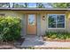 Close-up of the front door with stylish details, green shutters and plants at 6517 Kenwood Dr, North Port, FL 34287