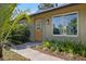 Inviting front entrance with stylish door, green shutters, and manicured plants at 6517 Kenwood Dr, North Port, FL 34287