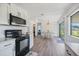Bright, modern kitchen with white cabinets, black appliances, and a view to the dining area at 6517 Kenwood Dr, North Port, FL 34287