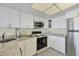 Modern kitchen with white cabinets, stainless steel appliances, and granite counters at 7070 Placida Rd # 1221, Placida, FL 33946