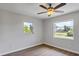 Bedroom with wood-look floors, ceiling fan and two windows at 189 Bunker Rd, Rotonda West, FL 33947