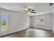 Bright bedroom with wood-look floors, ceiling fan, and large windows at 189 Bunker Rd, Rotonda West, FL 33947