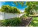 Landscaped backyard with a white fence and bird bath at 1867 Neptune Dr, Englewood, FL 34223