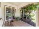 Inviting front porch with tiled flooring, wooden bench, and lush landscaping at 1867 Neptune Dr, Englewood, FL 34223