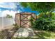 Tan and maroon storage shed with a wooden door at 1867 Neptune Dr, Englewood, FL 34223