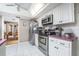 Kitchen boasts stainless steel appliances and white cabinets with pink countertops at 1867 Neptune Dr, Englewood, FL 34223