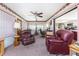 Bright sunroom has two burgundy leather recliners, and access to both living and kitchen areas at 1867 Neptune Dr, Englewood, FL 34223