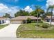 Ranch-style home with a two-car garage and mature landscaping at 1867 Neptune Dr, Englewood, FL 34223