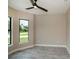 Bright bedroom with large window, ceiling fan, and grey tile floor at 205 Cougar Way, Rotonda West, FL 33947