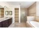 Bathroom featuring a large soaking tub, glass enclosed shower and double vanity with granite counters at 1012 Bradberry Dr, Nokomis, FL 34275