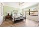 A spacious bedroom boasts wood floors, a ceiling fan, and a large window for ample natural light at 1012 Bradberry Dr, Nokomis, FL 34275