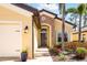 Close up view of a home's front entrance featuring a stone archway, beautiful landscaping, and a front-facing two car garage at 1012 Bradberry Dr, Nokomis, FL 34275