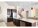 Modern kitchen design with stainless appliances, white countertops and dark wood cabinets adjacent to living room at 1012 Bradberry Dr, Nokomis, FL 34275