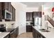 Kitchen featuring stainless steel appliances, dark wood cabinetry, stone countertops, and hanging pendant lights at 1012 Bradberry Dr, Nokomis, FL 34275