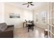 Home office with a desk, gray sofa and natural lighting from the arched window at 1012 Bradberry Dr, Nokomis, FL 34275