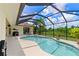 Inviting kidney-shaped pool with screened enclosure and outdoor kitchen at 14089 Newson Ln, Port Charlotte, FL 33981