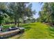 A lush green backyard with mature trees, a firepit, and access to a private boat dock at 200 Capstan Dr, Placida, FL 33946