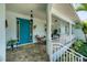 Charming front porch with a bright blue door, comfortable seating, and well-manicured landscaping at 200 Capstan Dr, Placida, FL 33946