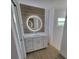 Bathroom features a vanity with wood backsplash, backlit mirror, and a frameless glass shower at 261 Broadmoor Ln, Rotonda West, FL 33947