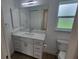 Bathroom features vanity with quartz countertops and frosted window at 261 Broadmoor Ln, Rotonda West, FL 33947