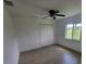 Bright bedroom with wood-look tile, ceiling fan, and a closet with bi-fold doors at 261 Broadmoor Ln, Rotonda West, FL 33947