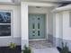 Inviting front entrance featuring a double door and tiled entryway framed by decorative plants and white trim at 261 Broadmoor Ln, Rotonda West, FL 33947