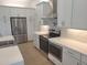 Modern kitchen with stainless steel appliances, white cabinets and quartz countertops at 261 Broadmoor Ln, Rotonda West, FL 33947