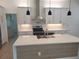 Modern kitchen with white cabinets, stainless steel appliances, quartz counters, and center island at 261 Broadmoor Ln, Rotonda West, FL 33947