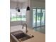 Bright kitchen features quartz counters, undermount sink, and stainless steel faucet with view to pool at 261 Broadmoor Ln, Rotonda West, FL 33947